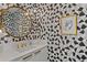 Modern powder room featuring patterned wallpaper, a gold-framed mirror, and stylish fixtures at 100 1St N Ave # 3905, St Petersburg, FL 33701