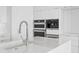 Sleek white kitchen featuring stainless steel appliances, integrated Miele coffee machine, and modern countertops at 100 1St N Ave # 3905, St Petersburg, FL 33701