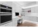 Modern kitchen featuring stainless steel ovens, white cabinetry, task lighting and built-in desk area at 100 1St N Ave # 3905, St Petersburg, FL 33701
