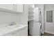 Bright laundry room equipped with a stacked washer and dryer, sink, and ample shelving for storage solutions at 100 1St N Ave # 3905, St Petersburg, FL 33701