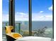 Relaxing view from bedroom featuring a sleek chair and breathtaking ocean scenery through large glass windows at 100 1St N Ave # 3905, St Petersburg, FL 33701