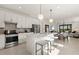 Open-concept kitchen with stainless steel appliances, quartz countertops, and bar seating at 10482 Sea Breeze Ridge Dr, Englewood, FL 34223