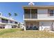 Exterior view of condo building with screened patio and view of palm trees at 112 Sun Isle Cir # 112, Treasure Island, FL 33706