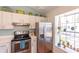 Charming kitchen with stainless steel appliances, white cabinetry, and window with natural light at 112 Sun Isle Cir # 112, Treasure Island, FL 33706
