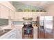 Well-lit kitchen with stainless steel appliances and white cabinets at 112 Sun Isle Cir # 112, Treasure Island, FL 33706