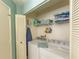 Practical laundry room with a washer, dryer, and storage shelves at 112 Sun Isle Cir # 112, Treasure Island, FL 33706