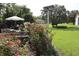 A backyard featuring a fountain, flowering shrubs, and a seating area with an umbrella at 11323 Highlander Ct, Spring Hill, FL 34609