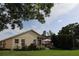 The backyard has a patio with a table, surrounded by lush landscaping, plants, and a manicured lawn at 11323 Highlander Ct, Spring Hill, FL 34609