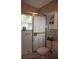 Bathroom with a shower and glass door, neutral countertops and patterned wallpaper at 11323 Highlander Ct, Spring Hill, FL 34609