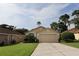 Attractive home with lush landscaping, a well-maintained lawn, and an attached two-car garage at 11323 Highlander Ct, Spring Hill, FL 34609