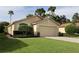 Charming single-story home with a well-manicured lawn and an attached two-car garage at 11323 Highlander Ct, Spring Hill, FL 34609