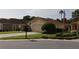 A well-kept lawn and manicured bushes lead to this tan home with an attached two-car garage at 11323 Highlander Ct, Spring Hill, FL 34609