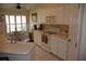 Eat-in kitchen features white cabinetry, neutral countertops and backsplash, and stainless steel appliances at 11323 Highlander Ct, Spring Hill, FL 34609