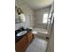 Bathroom featuring a single sink vanity, tiled shower, and toilet at 11423 77Th Ave, Seminole, FL 33772