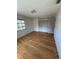 Bright bedroom featuring a built-in wardrobe and a window offering natural light on hardwood flooring at 11423 77Th Ave, Seminole, FL 33772