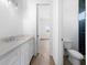 Bright bathroom with white cabinets, quartz countertops, a view into an adjacent room, and a toilet at 115 White Marsh Ln, Rotonda West, FL 33947