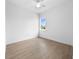 Empty bedroom with hardwood-style floors, ceiling fan, and a window with neighborhood view at 115 White Marsh Ln, Rotonda West, FL 33947