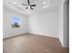Bright bedroom with a large window overlooking the lawn and light-colored wood-look flooring at 115 White Marsh Ln, Rotonda West, FL 33947