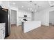 Open concept kitchen with a center island, white cabinetry, stainless steel appliances, and a view of the pantry at 115 White Marsh Ln, Rotonda West, FL 33947