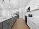Modern kitchen with sleek white cabinets, gray island, stainless steel appliances, and light wood floors at 115 White Marsh Ln, Rotonda West, FL 33947