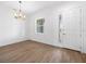 Bright living room featuring wood floors, a modern chandelier, and a window overlooking the front yard at 115 White Marsh Ln, Rotonda West, FL 33947