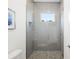 Bright shower features gray subway tile, a shower niche, hexagon floor tiles and frameless glass doors at 115 White Marsh Ln, Rotonda West, FL 33947