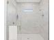 Bright shower with marble-patterned walls, a small window, white hexagonal tile flooring, and chrome hardware at 115 White Marsh Ln, Rotonda West, FL 33947