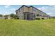 Spacious backyard with a screened-in patio, lush grass, and a partial view of the home's exterior at 11617 Crowned Sparrow Ln, Tampa, FL 33626