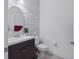 Stylish powder room with modern fixtures, decorative mirror, and a stone accent wall at 11617 Crowned Sparrow Ln, Tampa, FL 33626