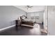 Bright bedroom with gray walls, a comfortable bed, a ceiling fan, and dark wood floors, creating a relaxing atmosphere at 11617 Crowned Sparrow Ln, Tampa, FL 33626