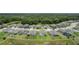 Wide aerial view of a community showcasing numerous homes, green spaces, and a serene pond at 12189 Nouveau Ave, Spring Hill, FL 34610