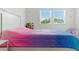 Bright bedroom with a large bed, playful decorations, and natural light from the two windows at 12189 Nouveau Ave, Spring Hill, FL 34610