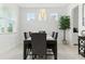 Bright dining room featuring an elegant chandelier, a modern dining table, and ample natural light from three windows at 12189 Nouveau Ave, Spring Hill, FL 34610