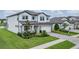 Beautiful two-story home with a paver driveway, manicured lawn, stone accents, and charming light blue shutters at 12189 Nouveau Ave, Spring Hill, FL 34610