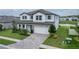Charming two-story home featuring a stone facade, beautiful landscaping, and a well-manicured lawn at 12189 Nouveau Ave, Spring Hill, FL 34610