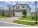 Well-maintained two-story home with a stone-accented facade, a paver driveway, and manicured landscaping at 12189 Nouveau Ave, Spring Hill, FL 34610