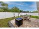 Backyard features a stone patio with fire pit and chairs at 12337 Rose Haven Blvd, New Port Richey, FL 34654