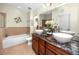Spacious bathroom featuring a double vanity with granite countertops, and a separate tub at 12337 Rose Haven Blvd, New Port Richey, FL 34654