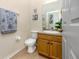 Half bath features a single sink vanity, a white toilet, and nautical decor at 12337 Rose Haven Blvd, New Port Richey, FL 34654