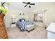 Bright bedroom features a ceiling fan, an exterior window, and coastal decorations at 12337 Rose Haven Blvd, New Port Richey, FL 34654