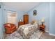Bedroom featuring blue walls, wood-look flooring, and an orange chair at 12337 Rose Haven Blvd, New Port Richey, FL 34654
