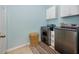 Bright laundry room has modern washer, dryer and storage cabinets at 12337 Rose Haven Blvd, New Port Richey, FL 34654