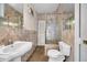 Bathroom featuring a pedestal sink, glass shower, and neutral tile at 1269 Drew St, Clearwater, FL 33755