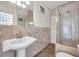 Bathroom featuring a pedestal sink, glass shower, and neutral tile at 1269 Drew St, Clearwater, FL 33755