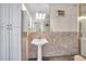 Bathroom features a pedestal sink, large mirror, marble tile, and a glass shower door at 1269 Drew St, Clearwater, FL 33755