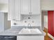 Kitchen sink area with white cabinets, tiled backsplash, and a stainless steel dishwasher at 1269 Drew St, Clearwater, FL 33755