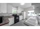 Well-lit kitchen featuring white cabinets, tile backsplash, modern appliances, and tile flooring at 1269 Drew St, Clearwater, FL 33755