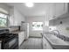 Bright kitchen features white cabinets, wood-look tile floors, and stainless steel appliances at 1269 Drew St, Clearwater, FL 33755