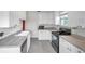 Charming kitchen featuring white cabinets, gray countertops, and stainless steel dishwasher at 1269 Drew St, Clearwater, FL 33755