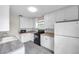 Well-lit kitchen features white cabinets, neutral countertops and a black range at 1269 Drew St, Clearwater, FL 33755